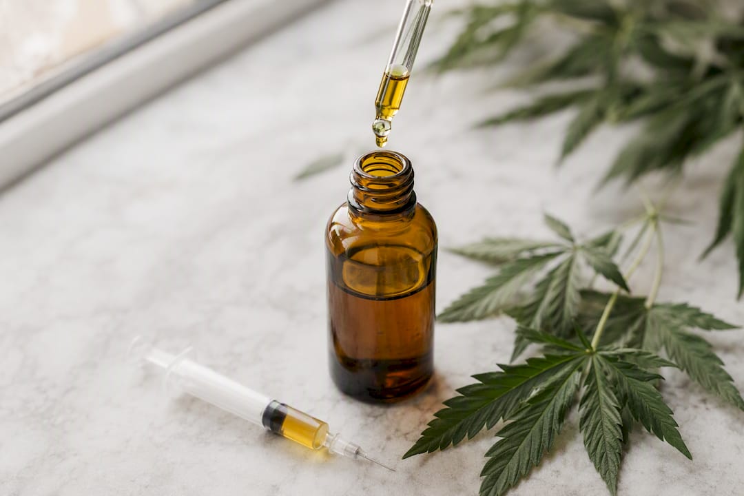 CBD chien dosage : combien de mg par kg et par jour donner ? - Pure Extract CBD Gros plan sur une bouteille d'huile de CBD avec compte-gouttes